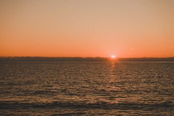 Scenic sunset or sunrise over sea surface. Natural scenery, beautiful landscape. Sunset or sunrise over sea surface