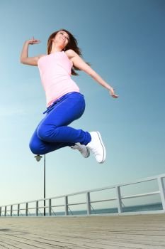 Attractive girl Young woman jumping in the sky