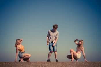 Friendship freedom summer holidays concept. Group of friends boy two girls spending time together guy dancing against sky. Group of friends boy two girls relaxing outdoor