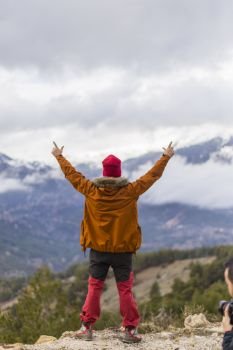 Happy man with open arms raised in mountains