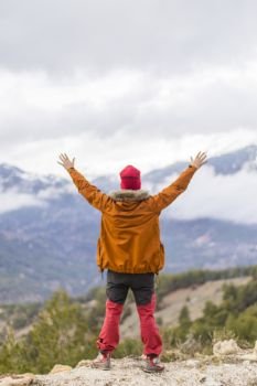 happy man with open arms raised in mountains