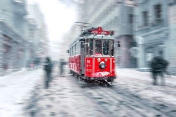 Motion Blurred:Winter view of nostalgic red Tram and people in daily life while snowing at popular Istiklal Street of Beyoglu,Istanbul,Turkey.07 January 2017. Winter view of nostalgic red Tram and people in daily life 