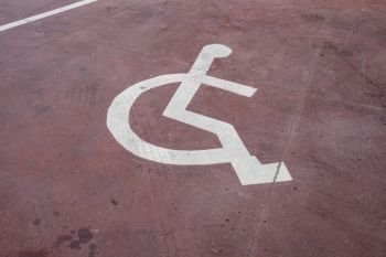 disabled white sign painted on a red floor