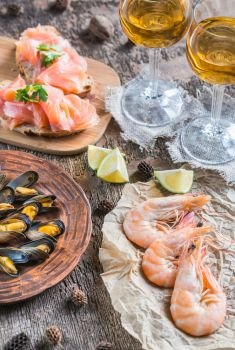 Seafood with two glasses of white wine on the wooden table