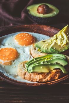Fried eggs with toasts and avocado