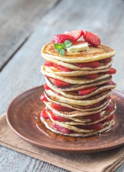 Stack of pancakes with fresh strawberries on the plate