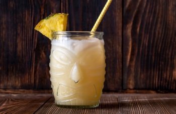 Glass of Painkiller cocktail on wooden background

