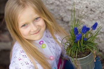 smiling girl holding flowers hyacinths  in a pot
