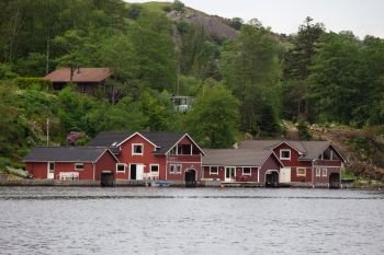 red norwegian houses on a lake coast
