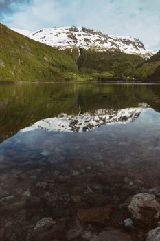 the beautiful Norwegian landscape. mountains in snow and reflection in water
