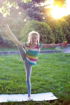 Healthy lifestyle - little girl doing yoga in the park. Healthy and Yoga Concept
