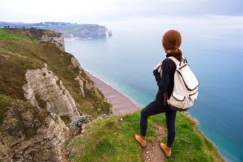 beautiful landscape, girl standing at the edge of rock in the Etretat. France
