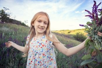 summer - beautiful girl on a meadow with a bouquet of salvia
