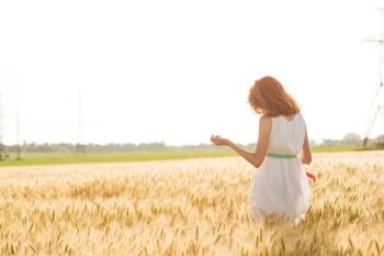 happy summer and freedom. Beautiful girl at the wheat field on a sunny day
