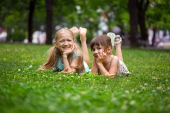 little smiling girls girlfriends on the lawn
