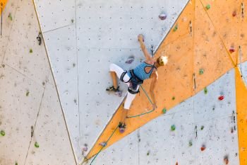 sport. bouldering - girl climbing up the wall
