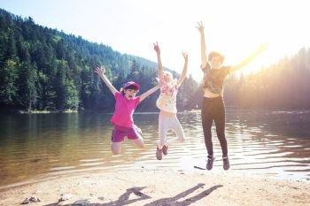 little children on a hike. Fun happy children jumping on the shore of a mountain lake synevyr. 
