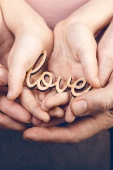concept of family values - hands holding word love
