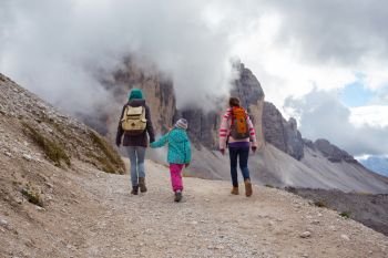 family - mother and two daughters  girls sisters hikers at the mountains Dolomites, Italy. Tre Cime di Lavaredo
