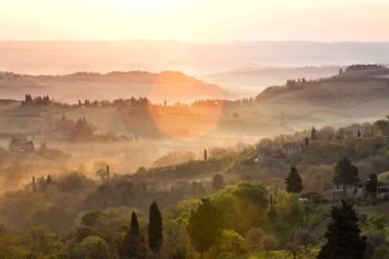 sunrise over tuscanian hills at the foggy morning. tuscany, italy
