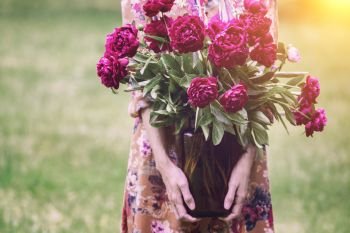 girl holding a jar with a bouquet of peonies. Spring
