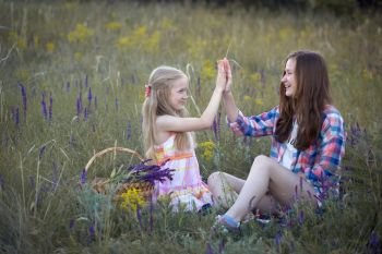 summer - Smiling girls sisters have fun in a meadow
