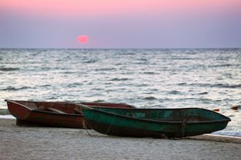 Two boats on the seashore at dawn
