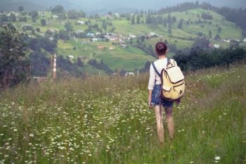 girl hiker with a backpack walking in the mountains. Vorokhta - Ukrainian landscape.
