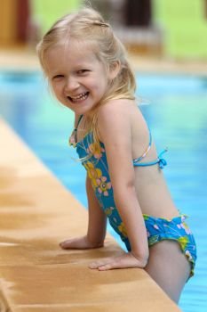 little girl  near the open-air swimming pool
