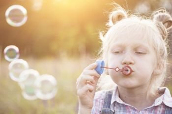 happy summer - girl blowing bubbles outdoors
