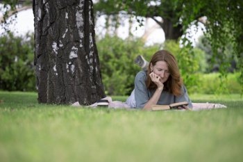 girl reading a book on the lawn
