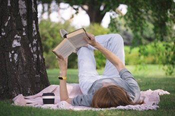 girl reading a book on the lawn
