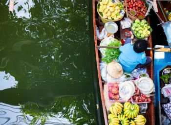 floating market - top view of boat full of fresh fruits on sale 