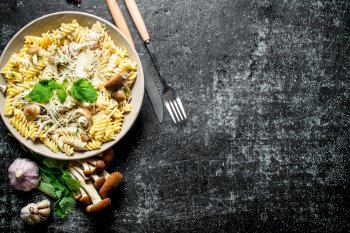 Fusilli pasta with mushrooms, garlic and mint leaves. On rustic background. Fusilli pasta with mushrooms, garlic and mint leaves.