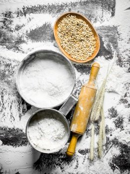 Flour in different sieve with grain, rolling pin and spikelets. On rustic background. Flour in different sieve with grain, rolling pin and spikelets.