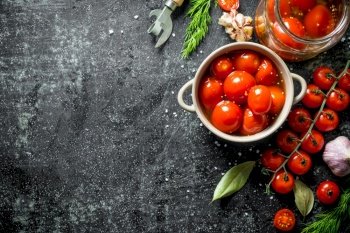 Pickled tomatoes in bowl with dill and fresh cherry tomatoes. On dark rustic background. Pickled tomatoes in bowl with dill and fresh cherry tomatoes.