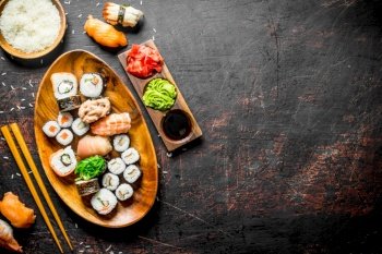 Traditional Japanese sushi and rolls with soy sauce and ginger. On dark rustic background. Traditional Japanese sushi and rolls with soy sauce and ginger.