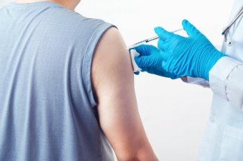 General practitioner vaccinating injection immunity Covid-19 vaccine dose to patient muscle arm shoulder on white background. Health and medical concept. Coronavirus epidemic inoculation theme