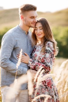 young loving couple hugging outdoors in the field on summer. concept of happiness and love. close up photo. love story.. young loving couple hugging outdoors in the field on summer. concept of happiness and love. close up photo. love story