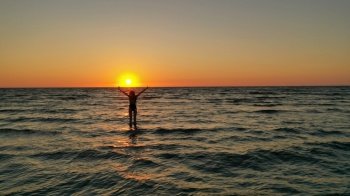 silhouette of a relaxed young girl in a bathing suit in the sea at sunrise. Happy Vacation Holiday Concept. silhouette of a relaxed young girl in a bathing suit in the sea at sunrise. Happy Vacation Holiday Concept.