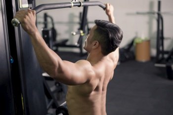 Bodybuilder man with big muscular  back in the gym 