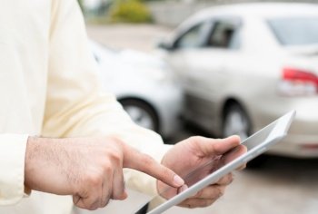 Businessman using a smartphone for taking a photo to send to insurance. Concept of claim insurance for a car accident online after send photo and evidence to the insurance company