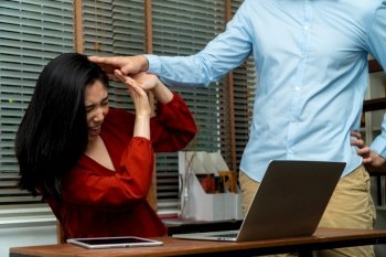 Boss attempts to touch the shoulder of a young female employee in office at workplace. She is uncomfortable and afraid of sexual inappropriate abuse. Concept of sexual harassment in the workplace