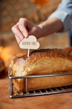 Sales Assistant In Bakery Putting Gluten Free Label Into Freshly Baked Gluten Free Sourdough Loaf