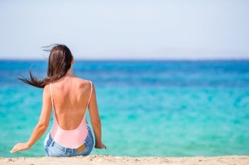 Young beautiful woman on the beach. Woman laying on the beach enjoying summer holidays looking at the sea