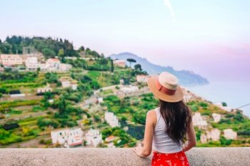 Beautiful woman in straw hat on the background of Amalfi Coast, Italy. Summer holiday in Italy. Young woman in Positano village on the background, Amalfi Coast, Italy