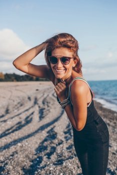 Beautiful happy woman on the beach smiling. Outdoor fashion portrait of stylish woman on the beach.