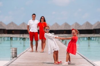Happy family have fun on wooden jetty during maldivian vacation. Beautiful happy family have fun on wooden jetty during summer vacation