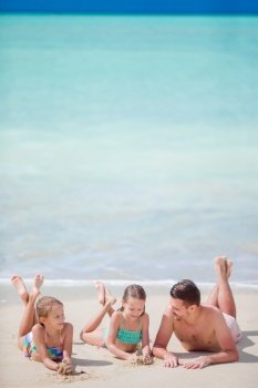 Father and kids enjoying beach summer vacation. Father and little kids enjoying beach summer tropical vacation. Family playing on the beach