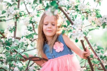 Adorable little girl in blooming apple garden on beautiful spring day. Adorable little girl enjoying spring day in apple blooming garden